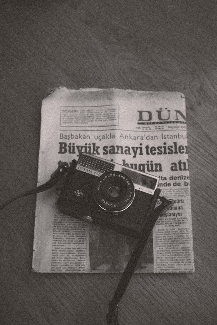 who-we-are Black and white photo of vintage camera on an old newspaper in Ankara, Türkiye.